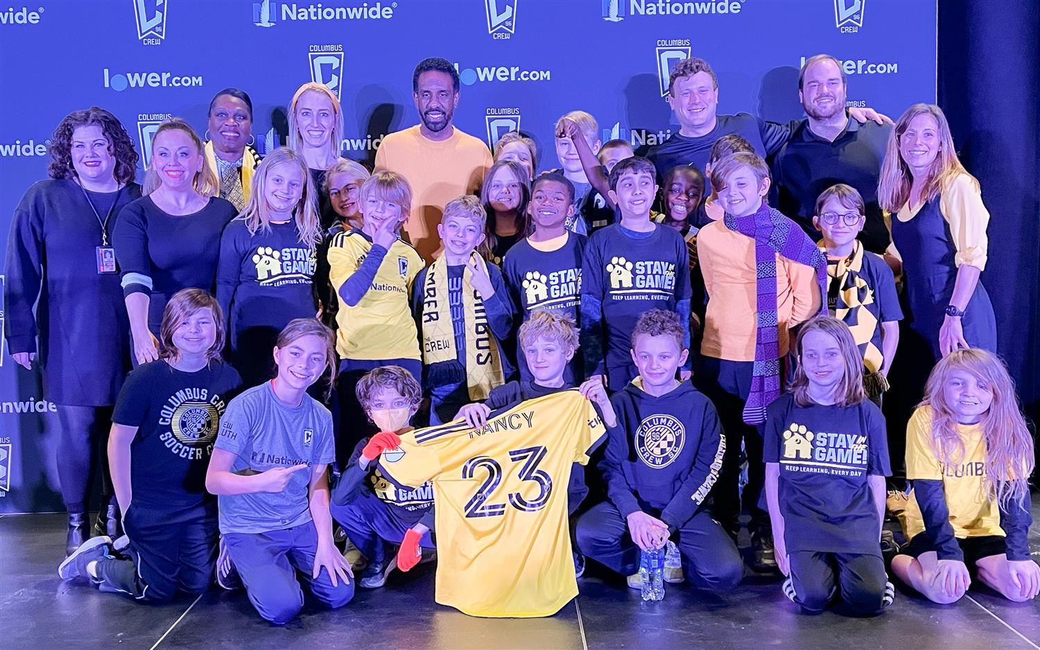 Students with Coach Nancy at press conference